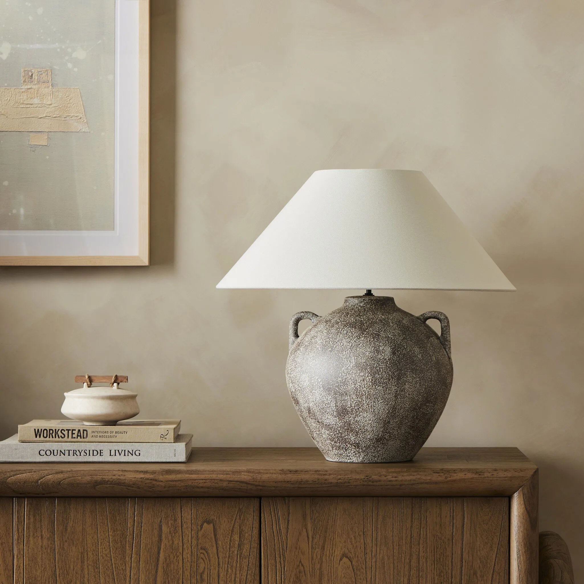 Featuring Mays Vintage Brown Ceramic Table Lamp by Four Hands at Amethyst Home. Inspired by vintage clay jars, a brown talavera lamp with handle-like detailing pairs with a tapered linen shade in a versatile ivory. Overall Dimensions: 22.00"w x 22.00"d x 21.00"h. Amethyst Home provides interior design, new home construction design consulting, vintage area rugs, and lighting in the Miami metro area.