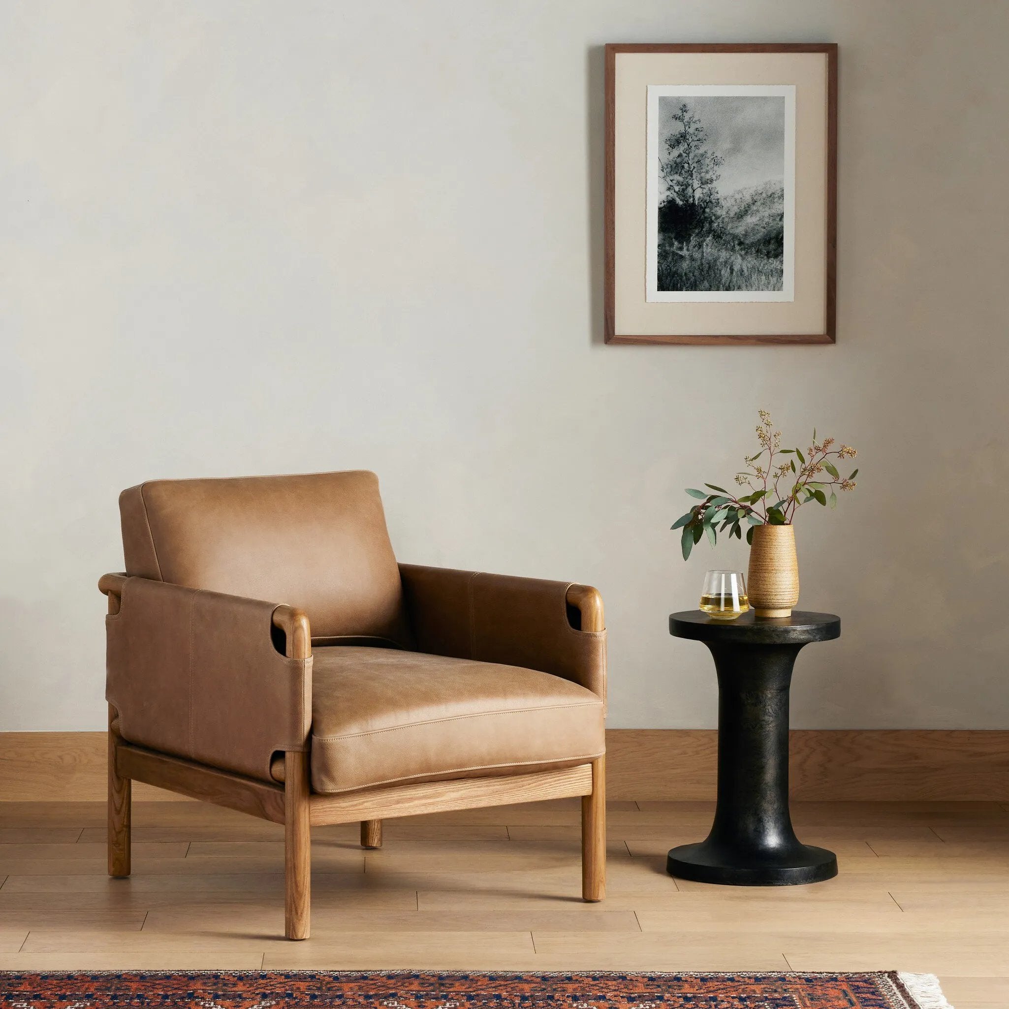 Safari inspiration meets zen aspirations. A cylindrical frame is crafted, smoothed and rounded from solid ash wood. Includes two loose feather-blend cushions covered in subtly distressed thick cut leather in a neutral taupe hue for a monochromatic look Amethyst Home provides interior design, new home construction design consulting, vintage area rugs, and lighting in the Newport Beach metro area.