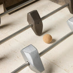 Inspired by Brutalist design, this outdoor foosball table is constructed of industrial oxidized aluminum panels, framing a travertine play surface atop a monolith plinth base that highlights the character of the finish. Two-toned players are cast in solid aluminum. Cover or store indoors during inclement weather and when not in use. Amethyst Home provides interior design, new home construction design consulting, vintage area rugs, and lighting in the Monterey metro area.