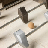 Inspired by Brutalist design, this outdoor foosball table is constructed of industrial oxidized aluminum panels, framing a travertine play surface atop a monolith plinth base that highlights the character of the finish. Two-toned players are cast in solid aluminum. Cover or store indoors during inclement weather and when not in use. Amethyst Home provides interior design, new home construction design consulting, vintage area rugs, and lighting in the Monterey metro area.
