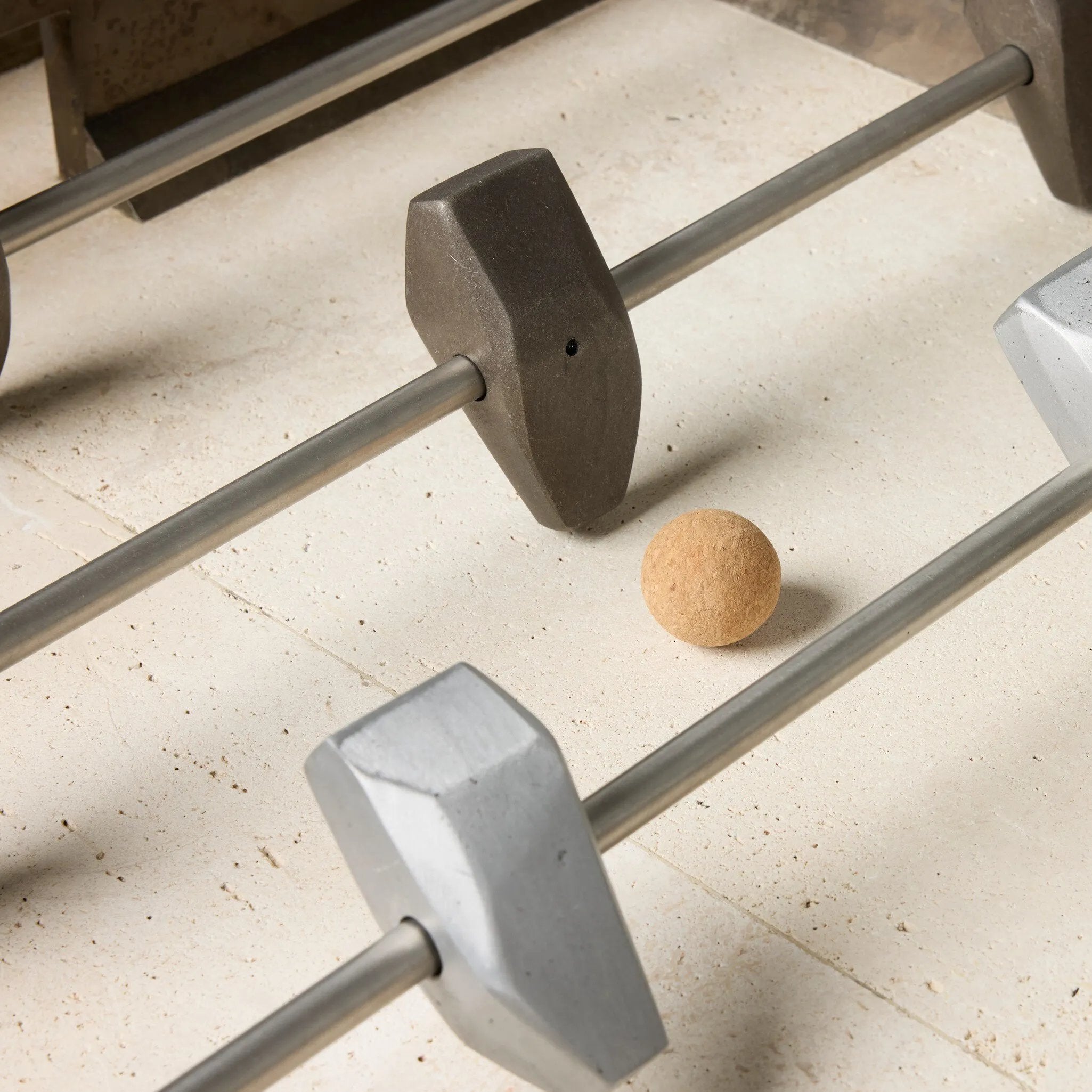 Inspired by Brutalist design, this outdoor foosball table is constructed of industrial oxidized aluminum panels, framing a travertine play surface atop a monolith plinth base that highlights the character of the finish. Two-toned players are cast in solid aluminum. Cover or store indoors during inclement weather and when not in use. Amethyst Home provides interior design, new home construction design consulting, vintage area rugs, and lighting in the Monterey metro area.
