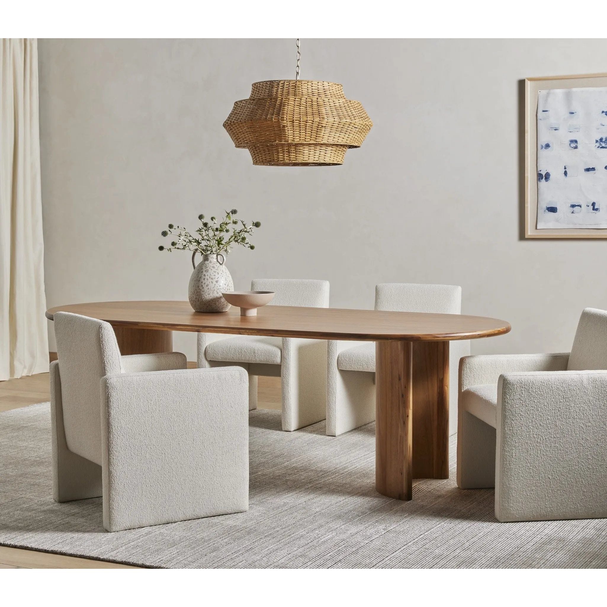 A study in shape. Sand-colored acacia forms crescent-shaped legs and a sprawling oval tabletop, bringing grand, organic-infused presence to the dining room Amethyst Home provides interior design, new home construction design consulting, vintage area rugs, and lighting in the Houston metro area.