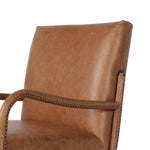 A slim seating style with timeless materials. An armless chair is fully upholstered in butterscotch top-grain leather with a subtle vintage look. Iron legs are also covered in leather, with exposed stitching along each leg. Finished with wooden armrests prime for the head of the table. Amethyst Home provides interior design, new home construction design consulting, vintage area rugs, and lighting in the Austin metro area.