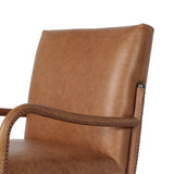 A slim seating style with timeless materials. An armless chair is fully upholstered in butterscotch top-grain leather with a subtle vintage look. Iron legs are also covered in leather, with exposed stitching along each leg. Finished with wooden armrests prime for the head of the table. Amethyst Home provides interior design, new home construction design consulting, vintage area rugs, and lighting in the Austin metro area.