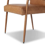 A slim seating style with timeless materials. An armless chair is fully upholstered in butterscotch top-grain leather with a subtle vintage look. Iron legs are also covered in leather, with exposed stitching along each leg. Finished with wooden armrests prime for the head of the table. Amethyst Home provides interior design, new home construction design consulting, vintage area rugs, and lighting in the Des Moines metro area.
