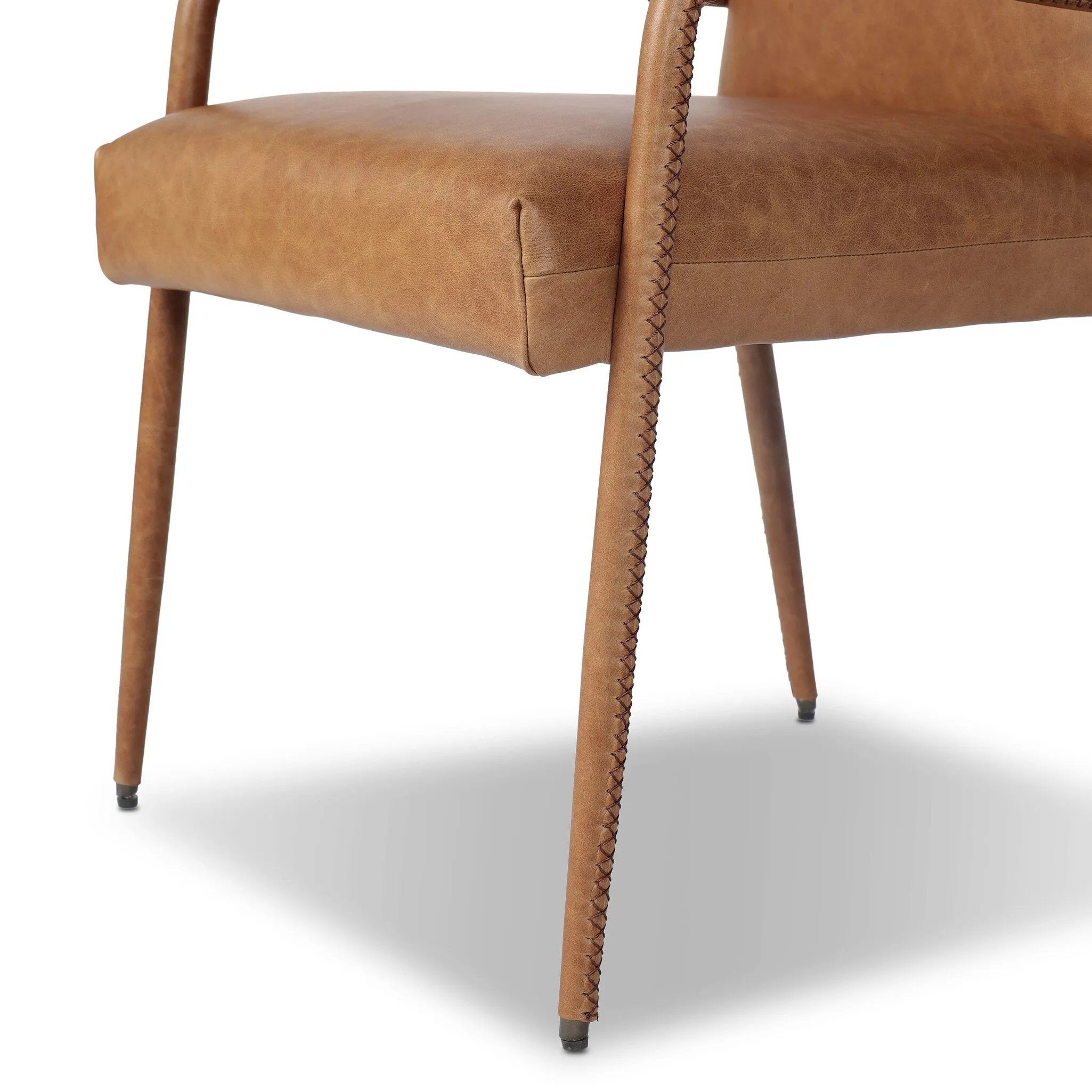 A slim seating style with timeless materials. An armless chair is fully upholstered in butterscotch top-grain leather with a subtle vintage look. Iron legs are also covered in leather, with exposed stitching along each leg. Finished with wooden armrests prime for the head of the table. Amethyst Home provides interior design, new home construction design consulting, vintage area rugs, and lighting in the Des Moines metro area.