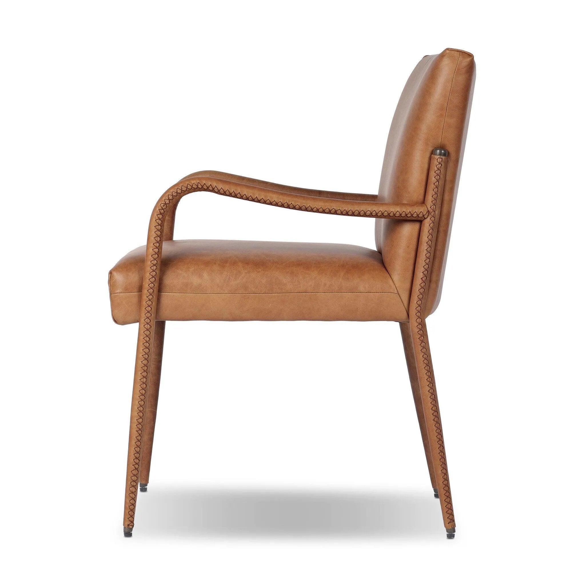 A slim seating style with timeless materials. An armless chair is fully upholstered in butterscotch top-grain leather with a subtle vintage look. Iron legs are also covered in leather, with exposed stitching along each leg. Finished with wooden armrests prime for the head of the table. Amethyst Home provides interior design, new home construction design consulting, vintage area rugs, and lighting in the Los Angeles metro area.