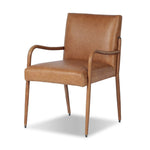 A slim seating style with timeless materials. An armless chair is fully upholstered in butterscotch top-grain leather with a subtle vintage look. Iron legs are also covered in leather, with exposed stitching along each leg. Finished with wooden armrests prime for the head of the table. Amethyst Home provides interior design, new home construction design consulting, vintage area rugs, and lighting in the Tampa metro area.