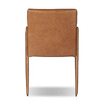 A slim seating style with timeless materials. An armless chair is fully upholstered in butterscotch top-grain leather with a subtle vintage look. Iron legs are also covered in leather, with exposed stitching along each leg. Finished with wooden armrests prime for the head of the table. Amethyst Home provides interior design, new home construction design consulting, vintage area rugs, and lighting in the Washington metro area.