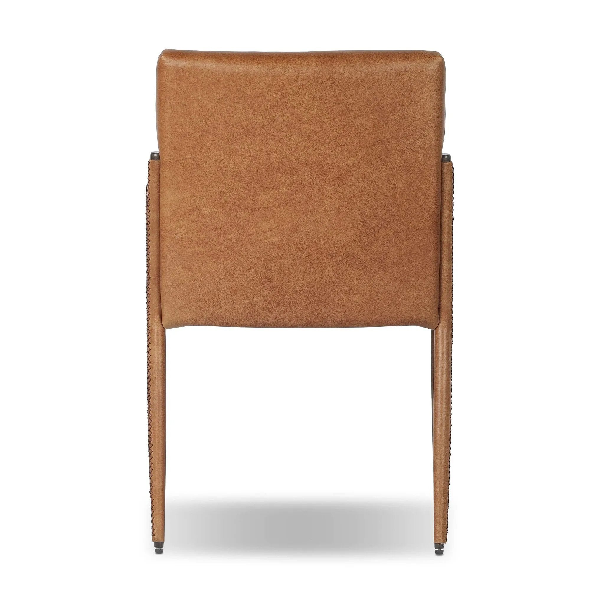 A slim seating style with timeless materials. An armless chair is fully upholstered in butterscotch top-grain leather with a subtle vintage look. Iron legs are also covered in leather, with exposed stitching along each leg. Finished with wooden armrests prime for the head of the table. Amethyst Home provides interior design, new home construction design consulting, vintage area rugs, and lighting in the Washington metro area.