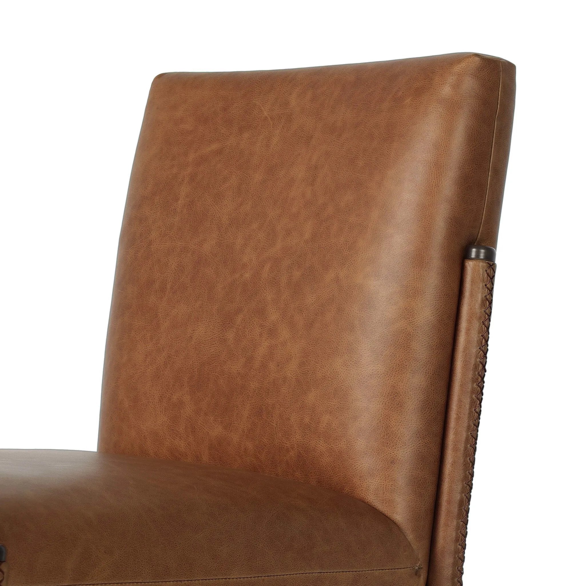 A slim seating style with timeless materials. An armless chair is fully upholstered in butterscotch top-grain leather with a subtle vintage look. Iron legs are also covered in leather, with exposed stitching along each leg.As enthusiasts of luxe design at Amethyst, we love the warm modern inspired Quill Dining Chair. Amethyst Home provides interior design, new home construction design consulting, vintage area rugs, and lighting in the San Diego metro area.