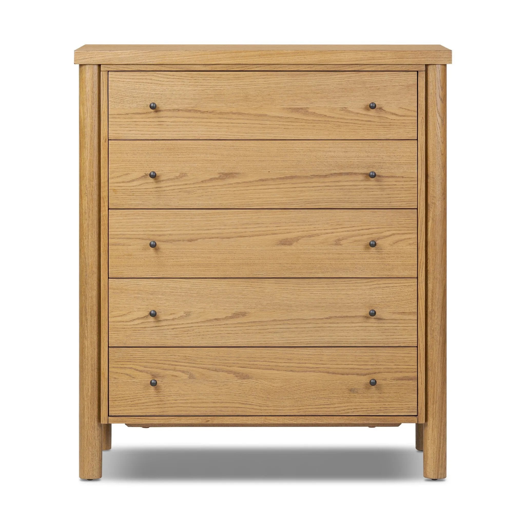 Create storage space in the bedroom with a five-drawer dresser of amber-finished oak. Chunky dowel legs support a tall silhouette and overhang top, all finished out with simple gunmetal hardware Amethyst Home provides interior design, new home construction design consulting, vintage area rugs, and lighting in the Austin metro area.