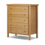 Create storage space in the bedroom with a five-drawer dresser of amber-finished oak. Chunky dowel legs support a tall silhouette and overhang top, all finished out with simple gunmetal hardware Amethyst Home provides interior design, new home construction design consulting, vintage area rugs, and lighting in the Houston metro area.