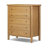 Create storage space in the bedroom with a five-drawer dresser of amber-finished oak. Chunky dowel legs support a tall silhouette and overhang top, all finished out with simple gunmetal hardware Amethyst Home provides interior design, new home construction design consulting, vintage area rugs, and lighting in the Houston metro area.