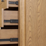 Create storage space in the bedroom with a five-drawer dresser of amber-finished oak. Chunky dowel legs support a tall silhouette and overhang top, all finished out with simple gunmetal hardware Amethyst Home provides interior design, new home construction design consulting, vintage area rugs, and lighting in the Los Angeles metro area.