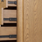 Create storage space in the bedroom with a five-drawer dresser of amber-finished oak. Chunky dowel legs support a tall silhouette and overhang top, all finished out with simple gunmetal hardware Amethyst Home provides interior design, new home construction design consulting, vintage area rugs, and lighting in the Los Angeles metro area.