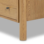 Create storage space in the bedroom with a five-drawer dresser of amber-finished oak. Chunky dowel legs support a tall silhouette and overhang top, all finished out with simple gunmetal hardware Amethyst Home provides interior design, new home construction design consulting, vintage area rugs, and lighting in the Nashville metro area.