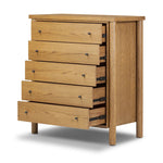 Create storage space in the bedroom with a five-drawer dresser of amber-finished oak. Chunky dowel legs support a tall silhouette and overhang top, all finished out with simple gunmetal hardware Amethyst Home provides interior design, new home construction design consulting, vintage area rugs, and lighting in the Portland metro area.