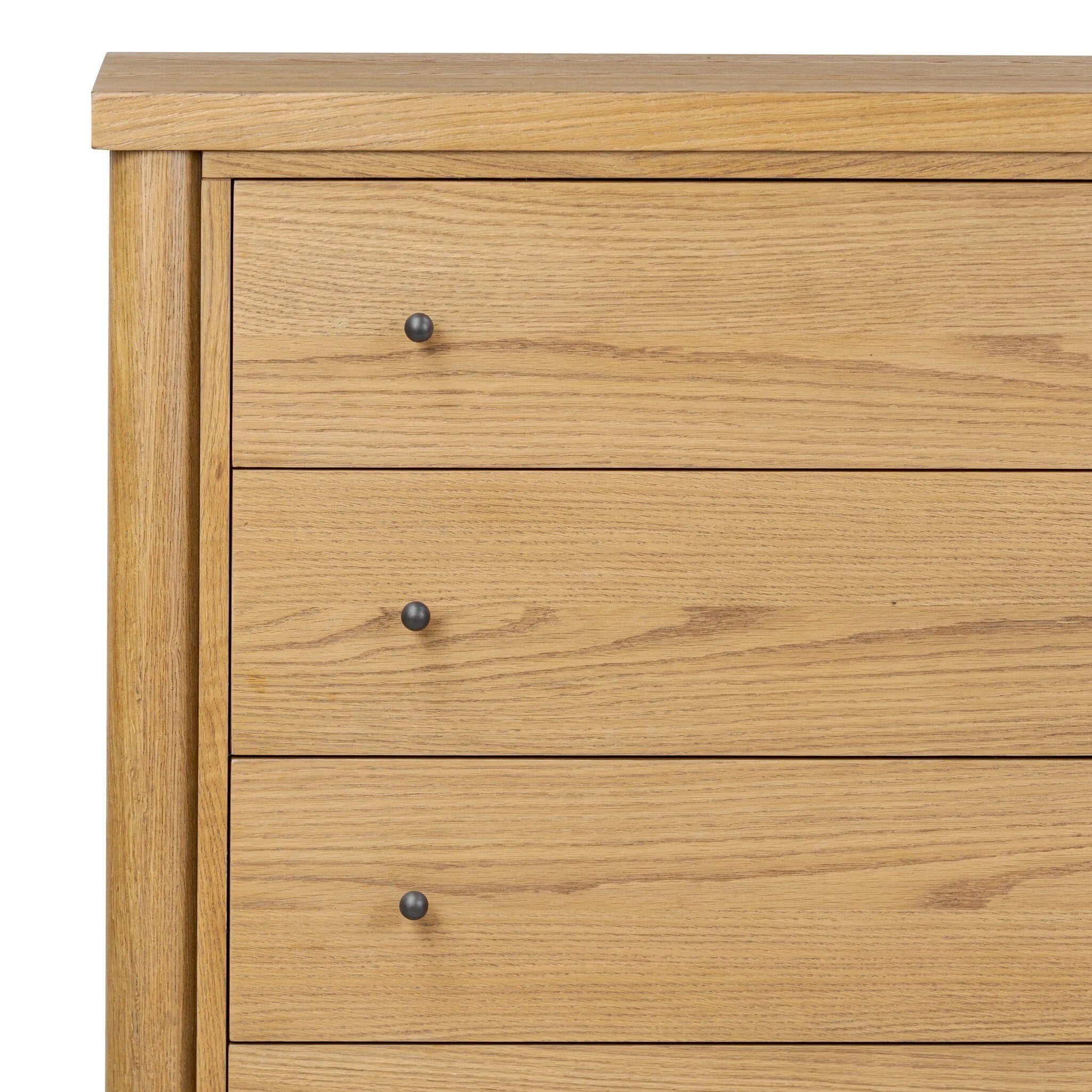 Create storage space in the bedroom with a five-drawer dresser of amber-finished oak. Chunky dowel legs support a tall silhouette and overhang top, all finished out with simple gunmetal hardware Amethyst Home provides interior design, new home construction design consulting, vintage area rugs, and lighting in the Washington metro area.