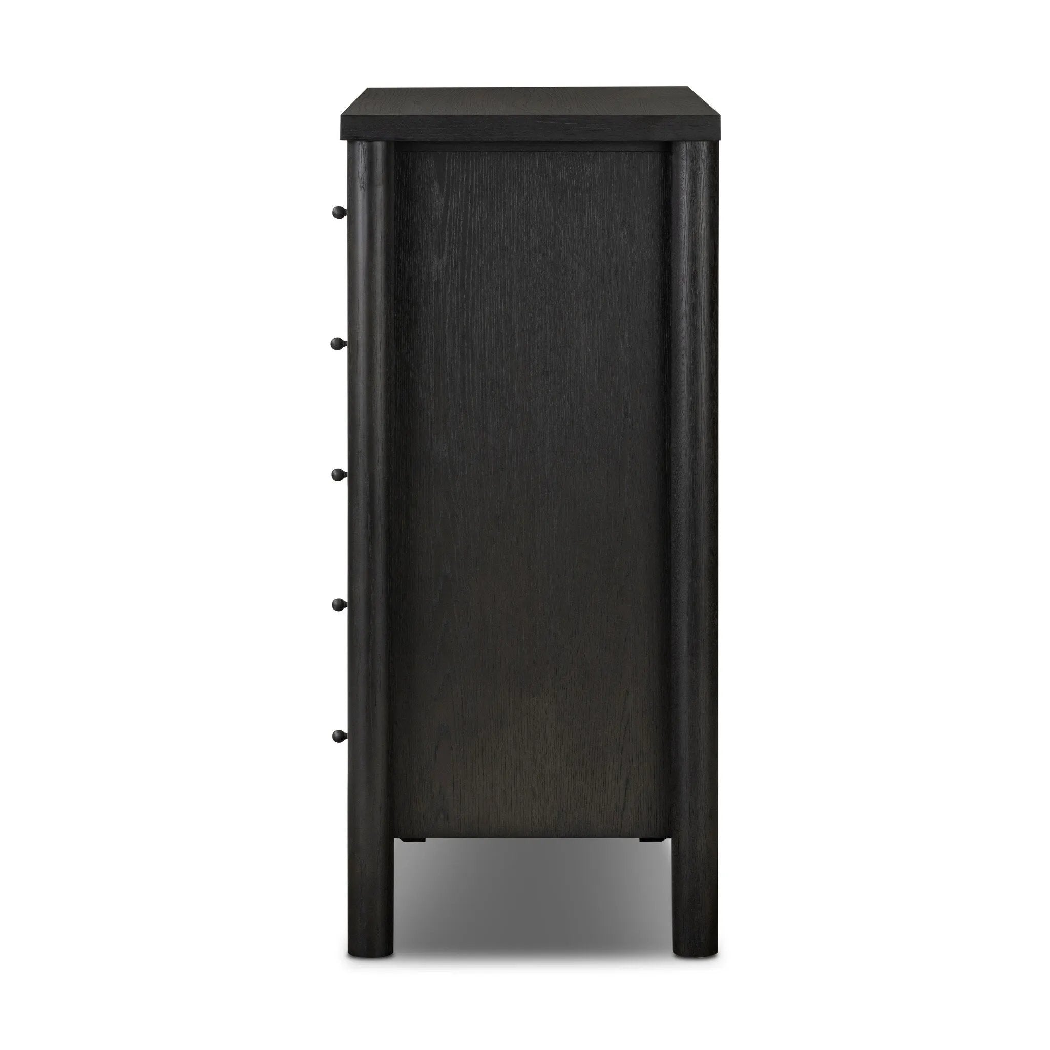 Create storage space in the bedroom with a five-drawer dresser of ebony-finished oak. Chunky dowel legs support a tall silhouette and overhang top, all finished out with simple gunmetal hardware Amethyst Home provides interior design, new home construction design consulting, vintage area rugs, and lighting in the Kansas City metro area.