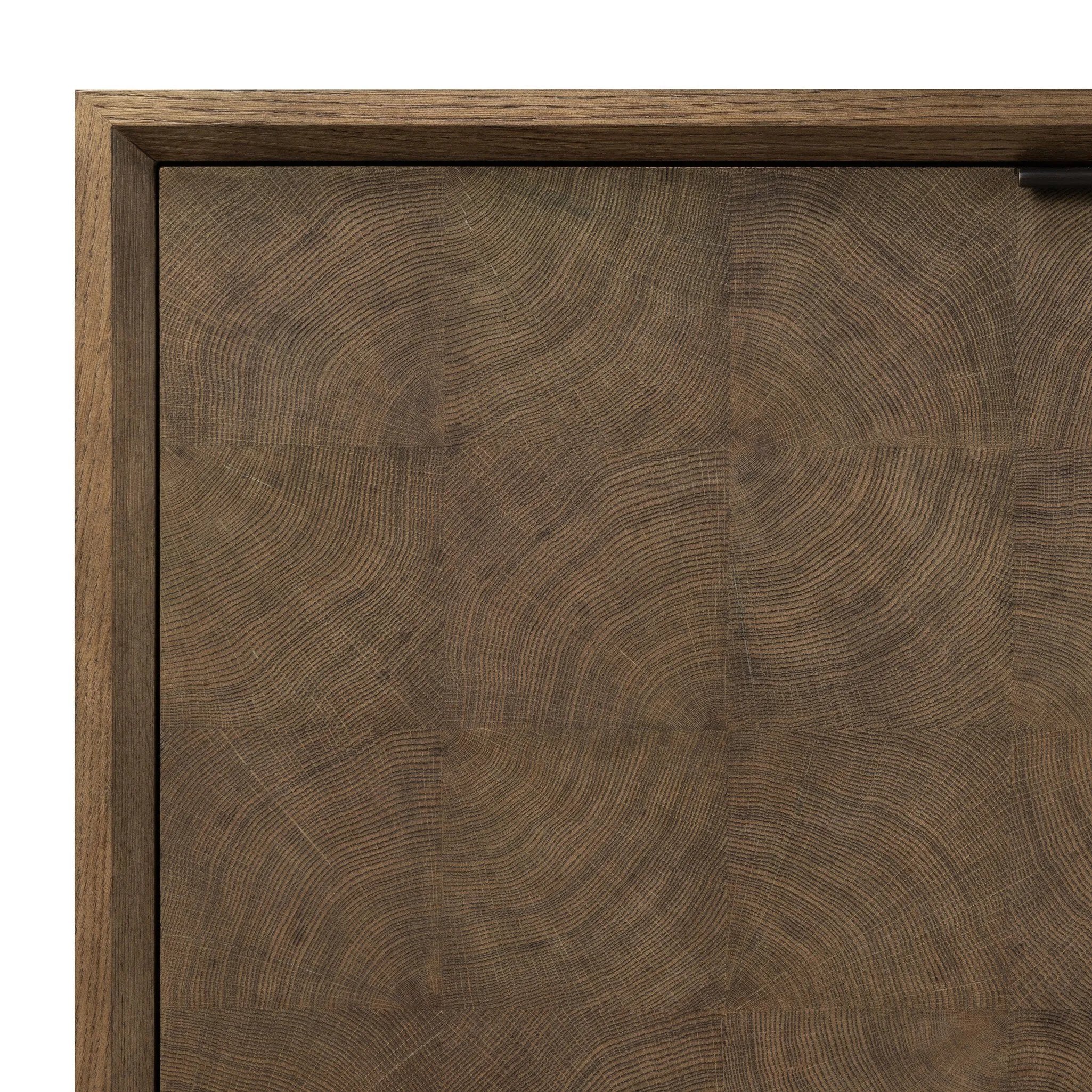 Grounding and stunning. We paired a modern frame and chunky base with door panels featuring oyster cuts of oak that take a specialized skill to create. Each cut captures the story of the wood and brings a natural, organic rhythm to the entire sideboard, and any space. Amethyst Home provides interior design, new home construction design consulting, vintage area rugs, and lighting in the San Diego metro area.