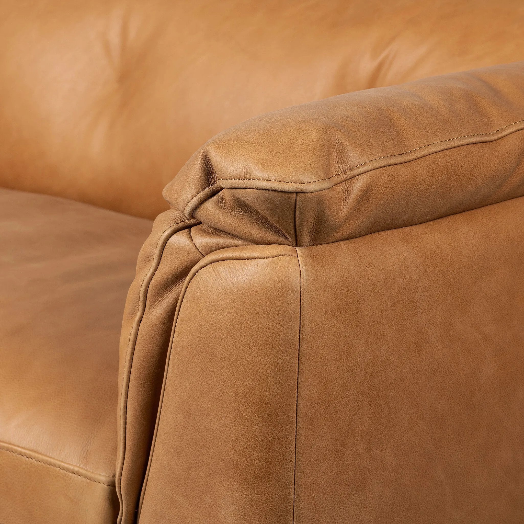 Inspired by 1970s Brutalism, this urban tuxedo sofa balances a rounded solid wood plinth with a curved seat deck and a relaxed, "wrinkled" upholstery design. Feather-blend cushions wrap the frame, finished with dramatic blind tufting for a hand-crafted, textural edge. Amethyst Home provides interior design, new home construction design consulting, vintage area rugs, and lighting in the Monterey metro area.