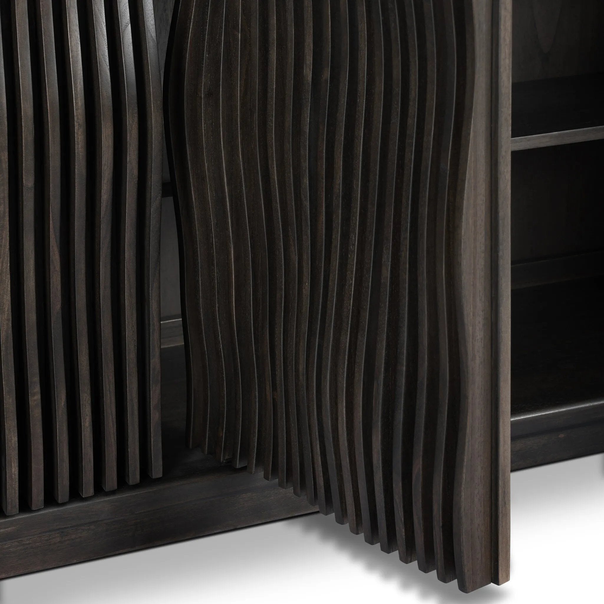 Bring a truly unique look to the dining or living space with this stunning sideboard inspired by rolling ocean tides. Crafted of solid mindi and mindi veneer, a stunning front features repetitive, flow-like reeding that's been precision-cut in individual pieces and assembled onto the doors, creating deep curves reminiscent of rippling waves. Amethyst Home provides interior design, new home construction design consulting, vintage area rugs, and lighting in the Los Angeles metro area.