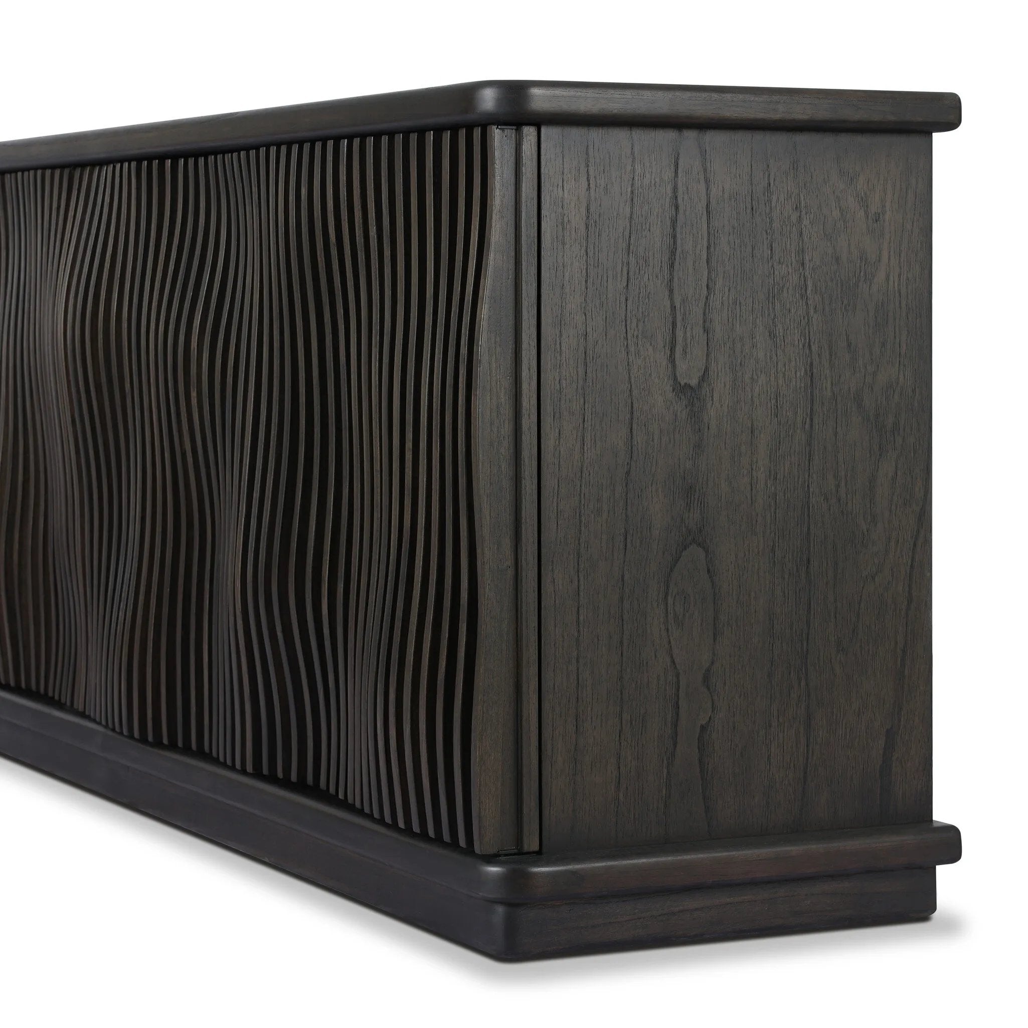 Bring a truly unique look to the dining or living space with this stunning sideboard inspired by rolling ocean tides. Crafted of solid mindi and mindi veneer, a stunning front features repetitive, flow-like reeding that's been precision-cut in individual pieces and assembled onto the doors, creating deep curves reminiscent of rippling waves. Amethyst Home provides interior design, new home construction design consulting, vintage area rugs, and lighting in the Tampa metro area.