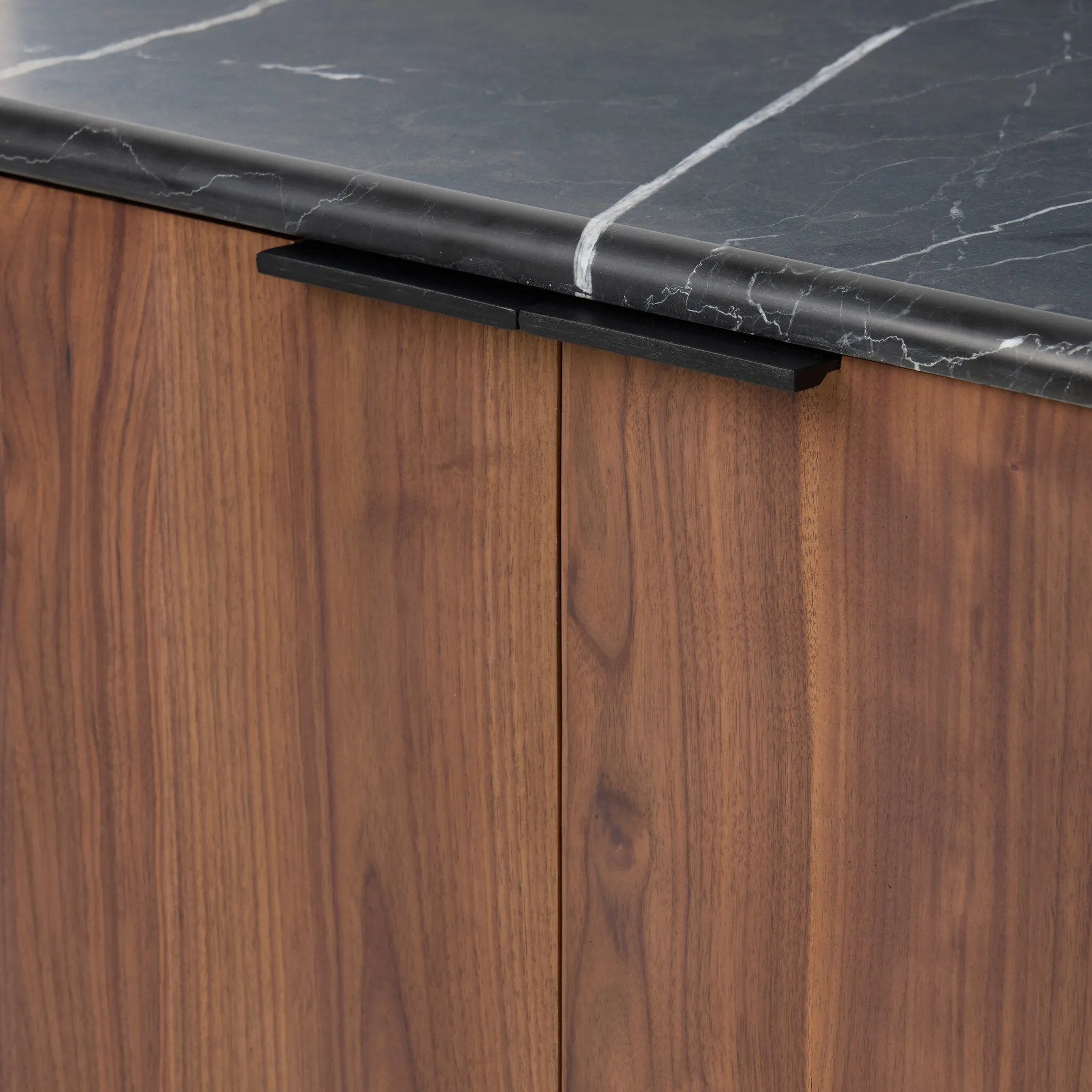 Design your space with hallmark features inspired by soft Brutalism. Made from solid walnut and poplar woods with a natural finish, the cabinet is topped with a black marble top with half bullnose edging for smooth contours. Double doors open to two shelves for ample storage. High-quality hardware is crafted from black iron. Amethyst Home provides interior design, new home construction design consulting, vintage area rugs, and lighting in the Tampa metro area.