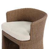 This outdoor dining chair takes on a curved silhouette, crafted from woven faux hyacinth and complemented by a heavily textured boucle cushion. Cover or store inside during inclement weather and when not in use.As lovers of natural materials at Amethyst, we love the designer inspired Thora Outdoor Dining Chair - Vada Cream. Amethyst Home provides interior design, new home construction design consulting, vintage area rugs, and lighting in the Washington metro area.