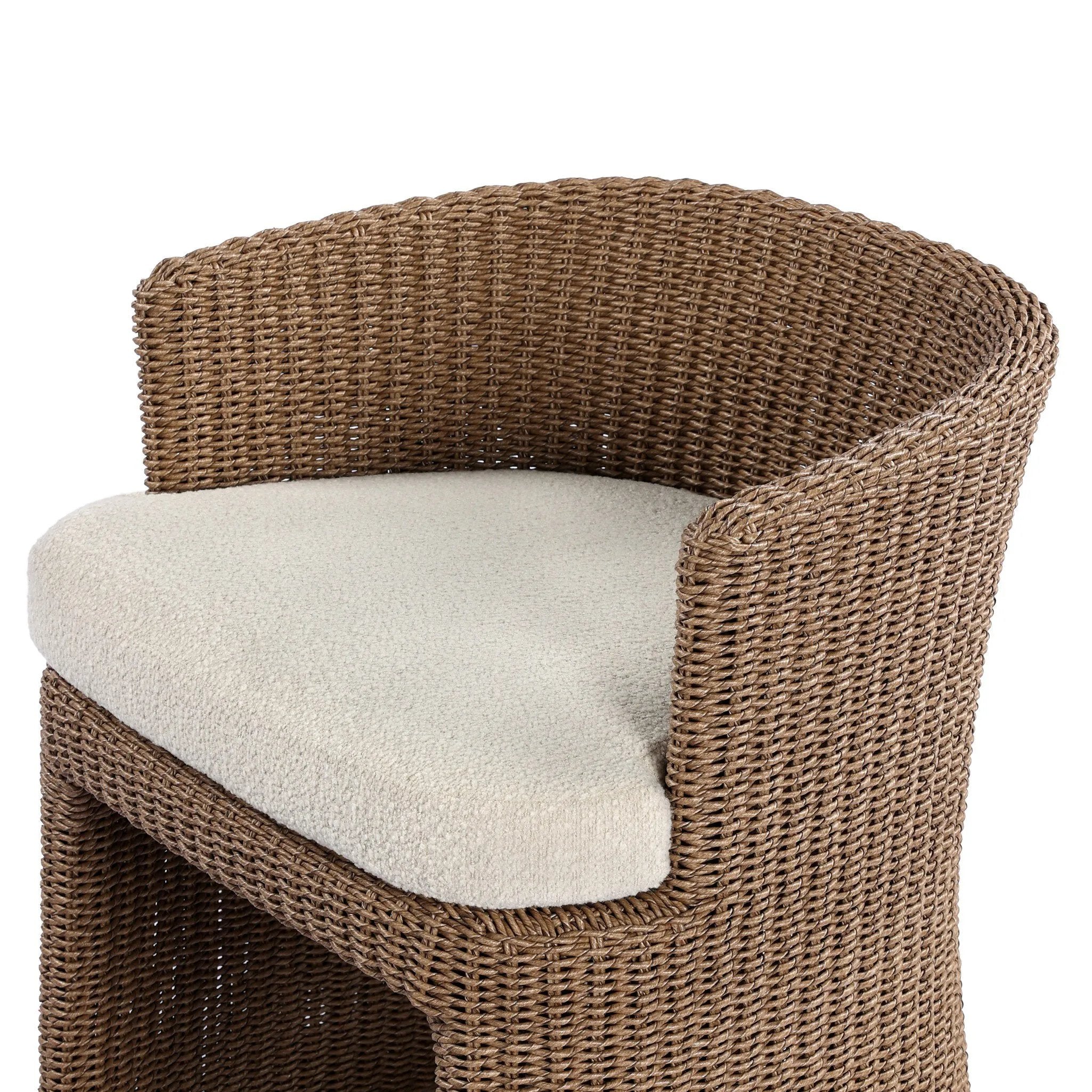This outdoor dining chair takes on a curved silhouette, crafted from woven faux hyacinth and complemented by a heavily textured boucle cushion. Cover or store inside during inclement weather and when not in use.As lovers of natural materials at Amethyst, we love the designer inspired Thora Outdoor Dining Chair - Vada Cream. Amethyst Home provides interior design, new home construction design consulting, vintage area rugs, and lighting in the Washington metro area.