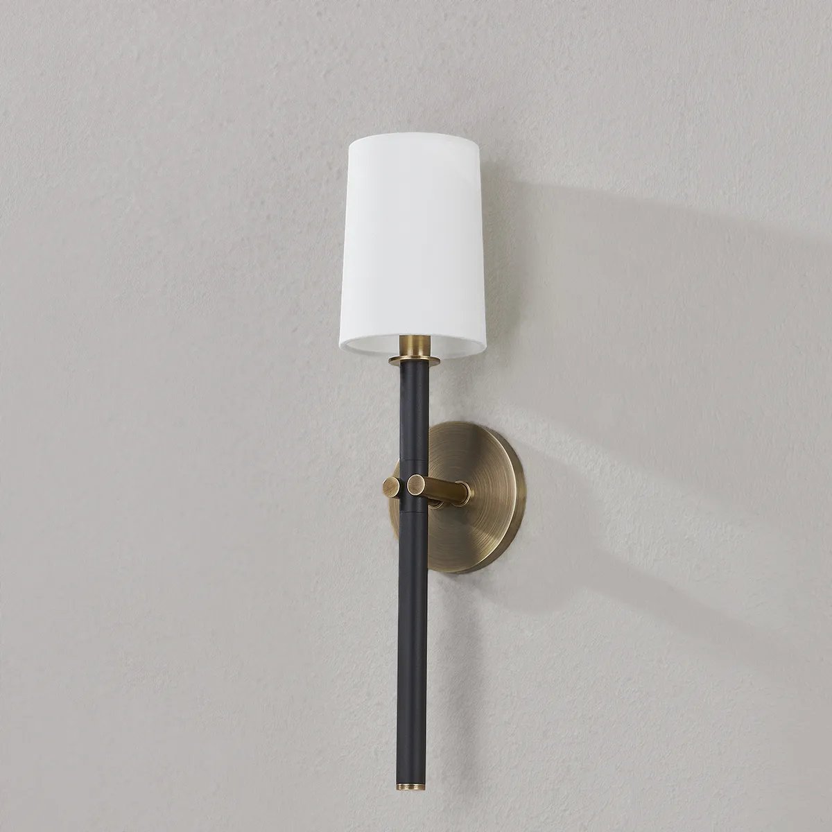 A traditional design with modern detailing, Belvedere is defined by its uniquely held candlesticks. Each Patina Brass arm on the ten-light chandelier holds two Texture Black candlesticks pierced through on opposing sides of the arm. The candlestick on the one-light wall sconce is pinched in place by two Patina Brass arms. Amethyst Home provides interior design, new home construction design consulting, vintage area rugs, and lighting in the Winter Garden metro area.