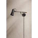 Tailored task lighting, this portable, functional swing arm sconce is also thoughtfully designed and beautiful. The sleek arm features a wooden handle on one end and an adjustable metal shade in Patina Brass or Bronze on the other. The twisted black cord detailing at the shade and backplate give Novel a nostalgic feel. Amethyst Home provides interior design, new home construction design consulting, vintage area rugs, and lighting in the Boston metro area.