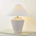Inspired by raw beauty of the desert, this whitewashed terracotta table lamp is calm and refreshing. The textural body contrasts beautifully with the angular tapered white linen shade. An Aged Brass frame provides a surprising metallic finish. Part of THELIFESTYLEDCO® collection. Amethyst Home provides interior design, new home construction design consulting, vintage area rugs, and lighting in the Winter Garden metro area.
