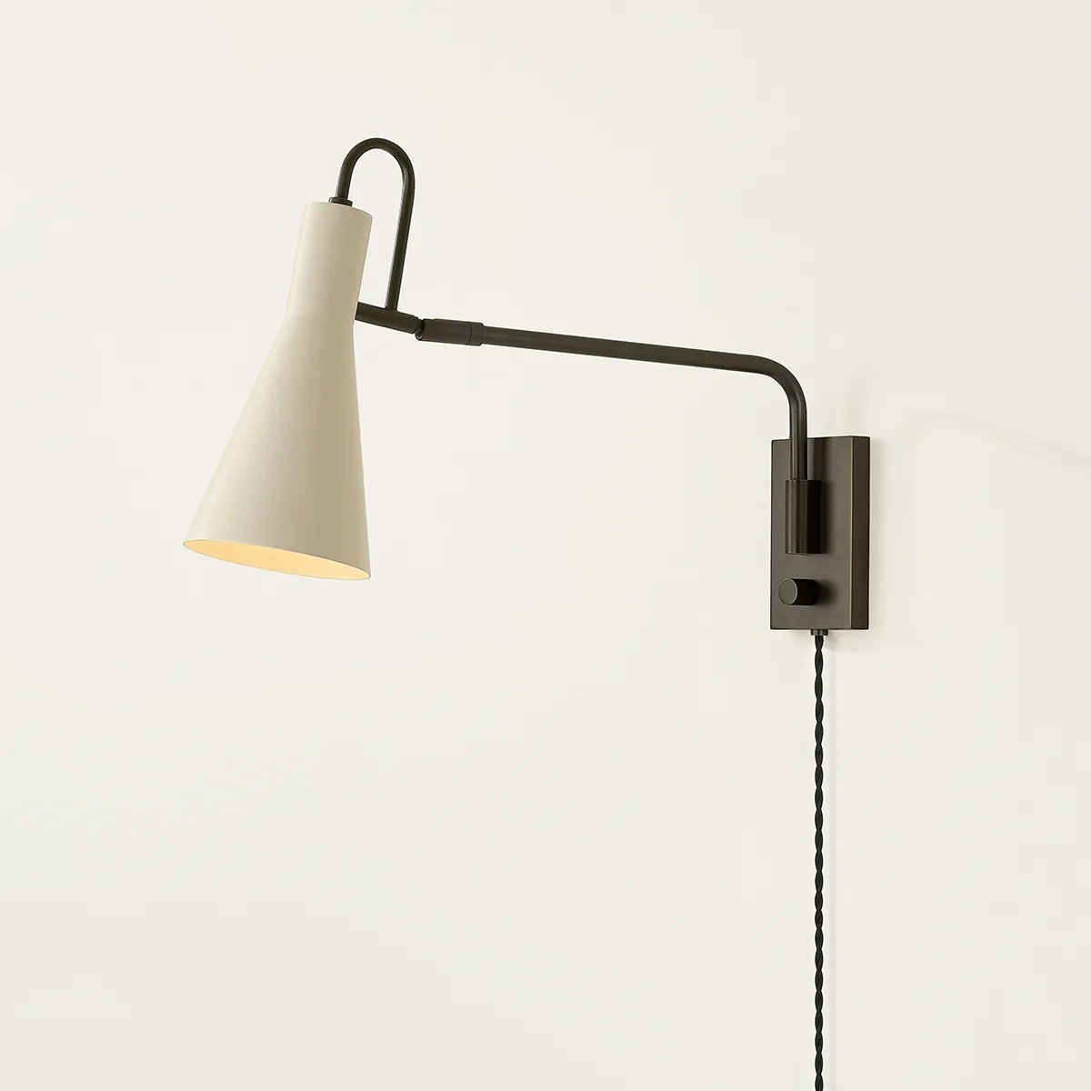 The Yvette plug-in sconce uses a modern lens to reimagine vintage design motifs. The geometry of the metalwork has been simplified to basic lines and curves, with the arc-shaped piece above the shade serving as a handle for adjustments. Finished in creamy Soft Bisque, this design-forward sconce adds plenty of directional light to a desk or bedside. Amethyst Home provides interior design, new home construction design consulting, vintage area rugs, and lighting in the Houston metro area.