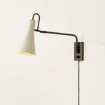 The Yvette plug-in sconce uses a modern lens to reimagine vintage design motifs. The geometry of the metalwork has been simplified to basic lines and curves, with the arc-shaped piece above the shade serving as a handle for adjustments. Finished in creamy Soft Bisque, this design-forward sconce adds plenty of directional light to a desk or bedside. Amethyst Home provides interior design, new home construction design consulting, vintage area rugs, and lighting in the Houston metro area.