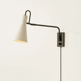 The Yvette plug-in sconce uses a modern lens to reimagine vintage design motifs. The geometry of the metalwork has been simplified to basic lines and curves, with the arc-shaped piece above the shade serving as a handle for adjustments. Finished in creamy Soft Bisque, this design-forward sconce adds plenty of directional light to a desk or bedside. Amethyst Home provides interior design, new home construction design consulting, vintage area rugs, and lighting in the Houston metro area.