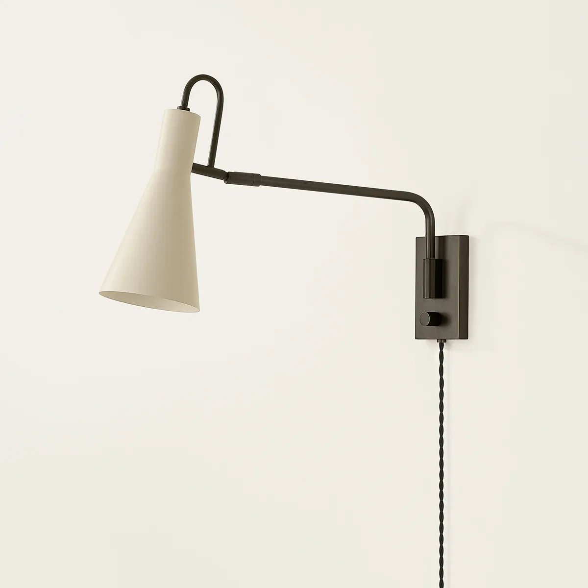 The Yvette plug-in sconce uses a modern lens to reimagine vintage design motifs. The geometry of the metalwork has been simplified to basic lines and curves, with the arc-shaped piece above the shade serving as a handle for adjustments. Finished in creamy Soft Bisque, this design-forward sconce adds plenty of directional light to a desk or bedside. Amethyst Home provides interior design, new home construction design consulting, vintage area rugs, and lighting in the Monterey metro area.