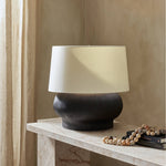Featuring Kragen Textured Matte Black Porcelain Ceramic Table Lamp by Four Hands at Amethyst Home. A wide, textured table lamp of black-finished ceramic pairs with an ivory shade of flax and linen.Overall Dimensions: 18.00"w x 18.00"d x 23.00"hWeight : 19.27 lbsMaterials : Ceramic, 65% Polyester, 35% Flax/Linen. Amethyst Home provides interior design, new construction, custom furniture, and area rugs in the Park City metro area