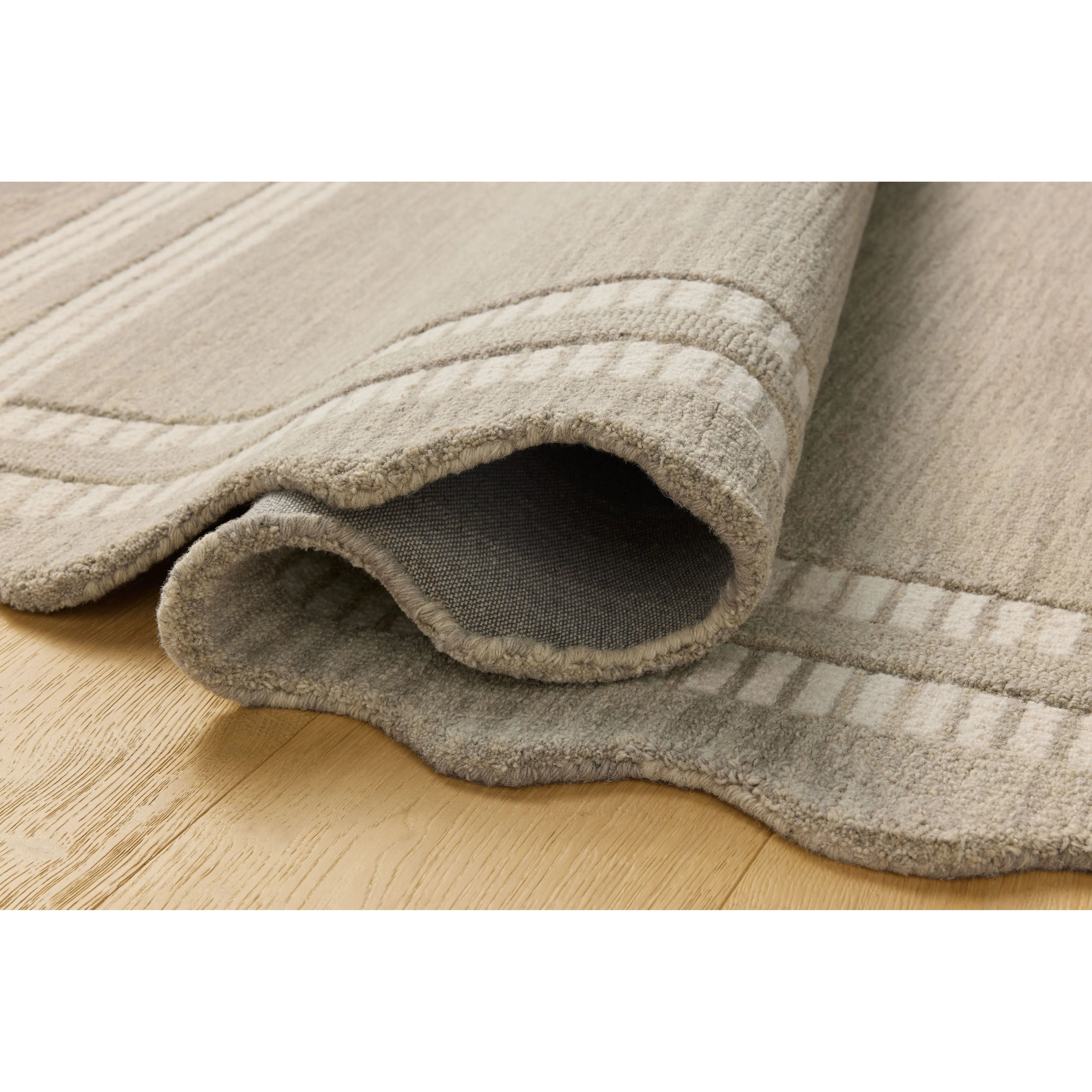 Featuring Chris Loves Julia × Loloi Scottie Fog / Ivory Rug by Loloi at Amethyst Home. The Scottie Collection from Chris Loves Julia x Loloi is a hand-tufted wool area rug with a playful scalloped edge and lower-pile, striped border for a touch of structure. The rugs overall pile is thick and plush, available in easygoing earth tones and neutral colorways. Amethyst Home provides interior design, new home construction design consulting, vintage area rugs, and lighting in the Kansas City metro area.