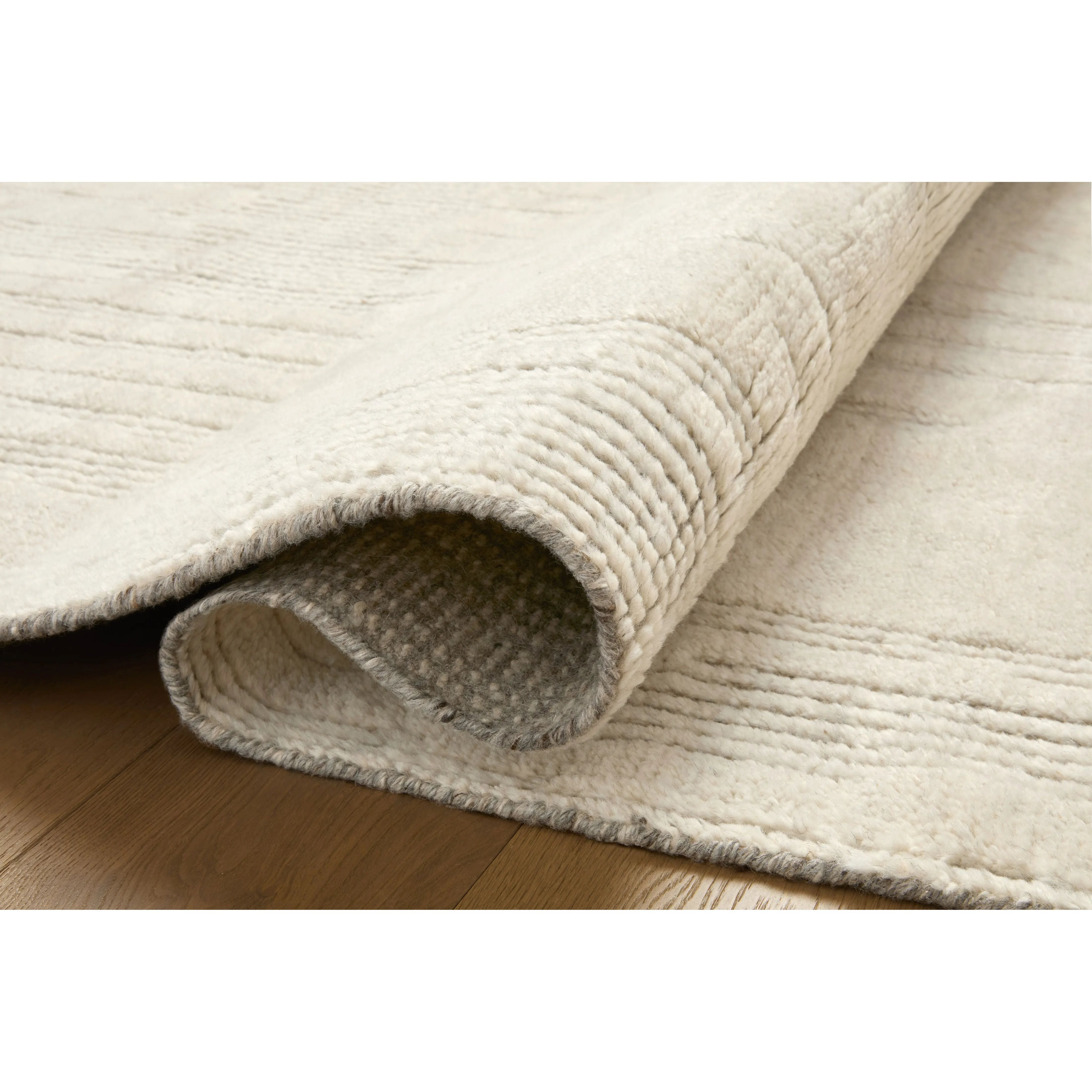Featuring David Jean Stoffer x Loloi Ivory Hand-Knotted Rug by Loloi at Amethyst Home. Unexpected stripes trace along the David Collection, a hand-knotted area rug with a plush, luxurious presence. Abstract patterns are carved into the design for a richly textured pile that's satisfying to sink into. This collection is made of 100% wool in India and GoodWeav. Amethyst Home provides interior design, new home construction design consulting, vintage area rugs, and lighting in the Portland metro area.