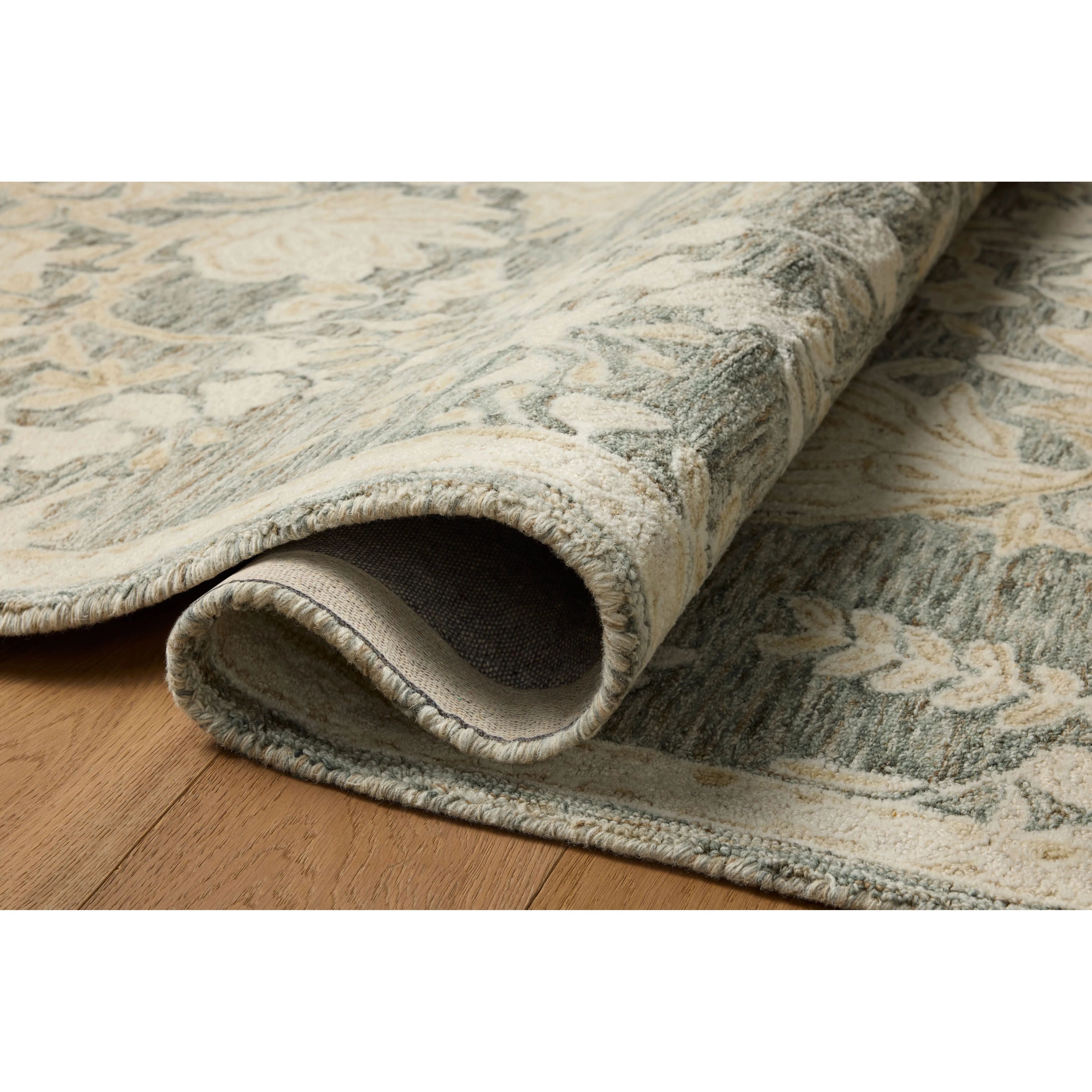 The Lenore Collection is a floral wool area rug with a two-toned design for elegant home decor. The rug's intricate linework is cut pile and the base is looped yarn, which gives the florals a slightly raised appearance and lovely depth. Amethyst Home provides interior design, new home construction design consulting, vintage area rugs, and lighting in the Portland metro area.