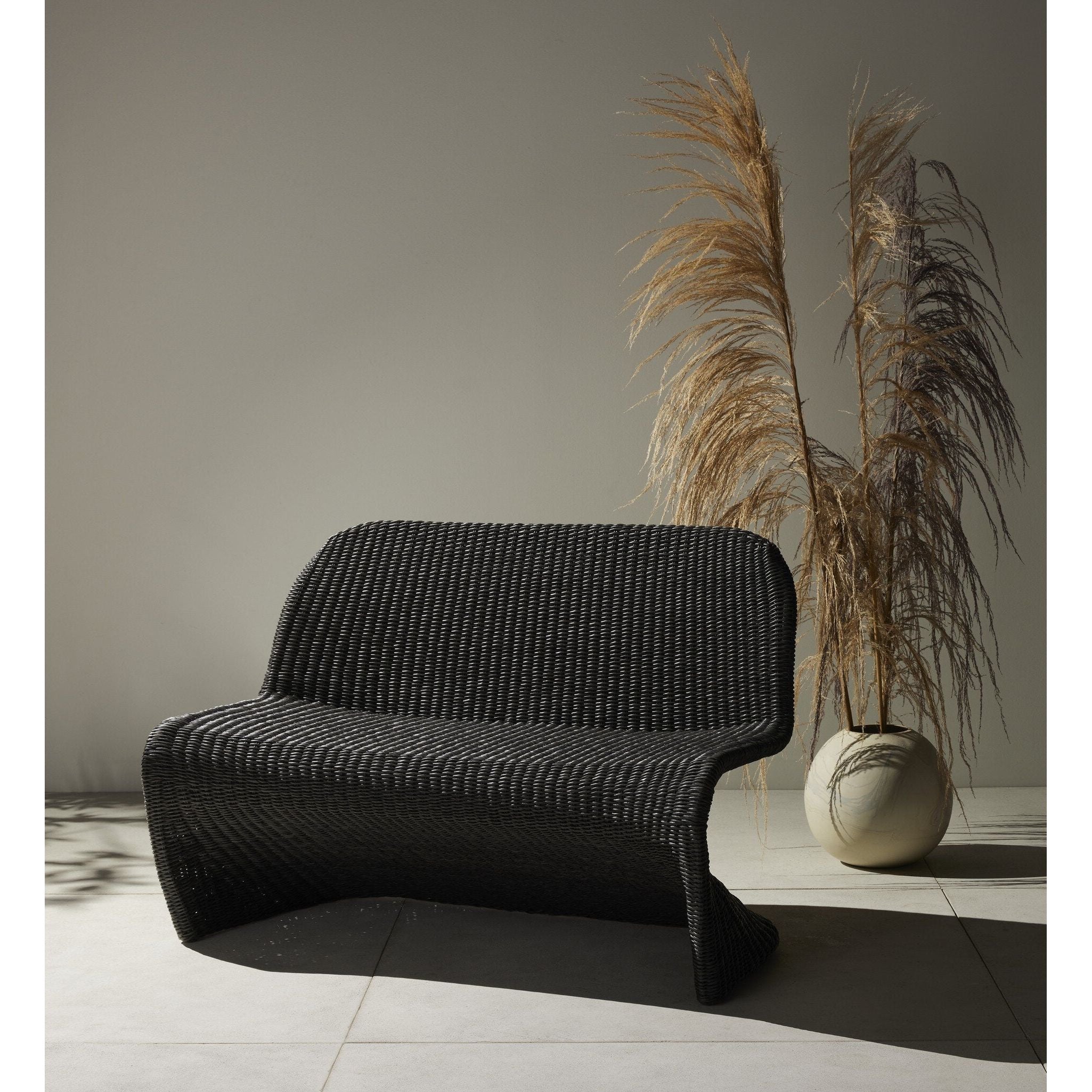 Featuring Portia Vintage Coal Outdoor Dining Bench by Four Hands at Amethyst Home. Based off a vintage shape, all-weather wicker seating brings dramatic curves to this statement-making dining bench.Overall Dimensions: 50.00"w x 27.00"d x 34.00"hWeight : 69.22 lbsMaterials : 100% Polyethylene, Iron. Amethyst Home provides interior design, new construction, custom furniture, and area rugs in the Tampa metro area