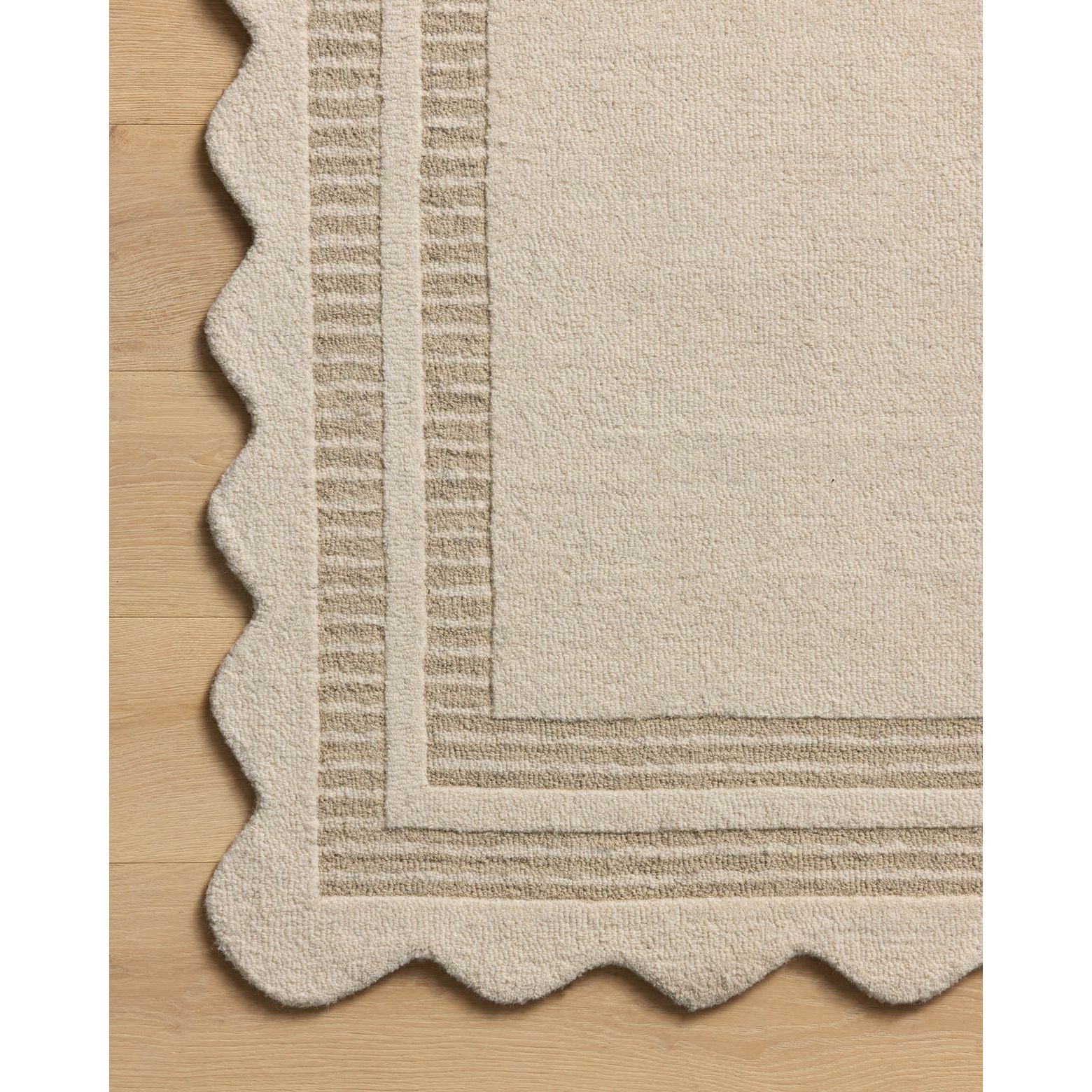 Featuring Chris Loves Julia × Loloi Scottie Ivory / Grey Rug by Loloi at Amethyst Home. The Scottie Collection from Chris Loves Julia x Loloi is a hand-tufted wool area rug with a playful scalloped edge and lower-pile, striped border for a touch of structure. The rugs overall pile is thick and plush, available in easygoing earth tones and neutral colorway.  Amethyst Home provides interior design, new home construction design consulting, vintage area rugs, and lighting in the Washington metro area.