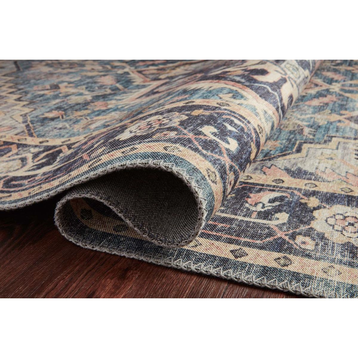 Featuring soft motifs in a carefully curated color palate of black, blue, yellow, and hints of orange, the Hathaway Navy / Multi area rug captures the essence of one-of-a-kind vintage or antique area rug at an attractive price.