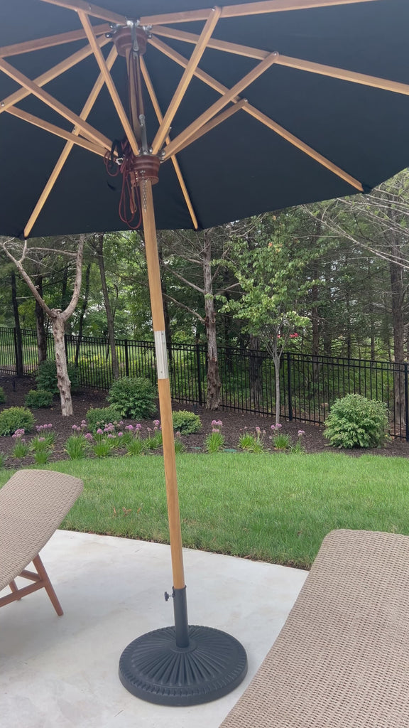 Inspired by the packable nature of 1800s campaign-style pieces, this outdoor umbrella features a teak pole and black canopy operated by a pulley system. Leather detailing and a woven rope cord offer subtle yet sophisticated finishes. Base sold separately. Cover or store indoors during inclement weather and when not in use.Overall Dimensions: 118.00"w x 118. Amethyst Home provides interior design, new home construction design consulting, vintage area rugs, and lighting in the Salt Lake City metro area.
