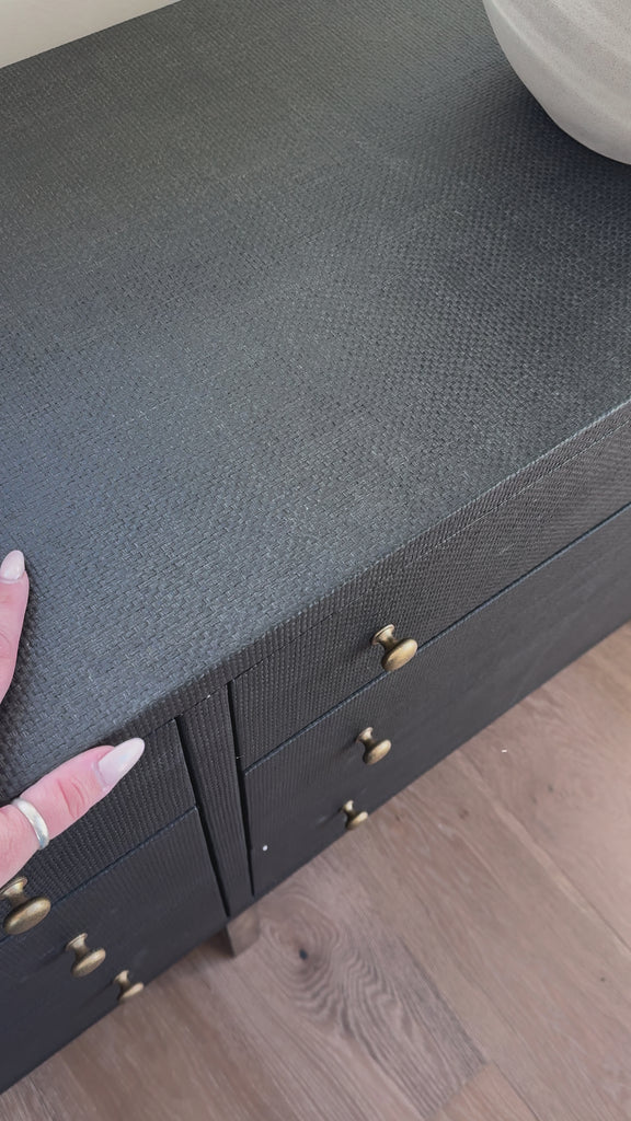 Woven black raffia offers a texture-driven take on bedroom storage. Antique brass-finished iron hardware adorns six spacious drawers, all supported by a solid mahogany base.Overall Dimensions: 62.00"w x 17.00"d x 34.00"hWeight : 181.22 lbsMaterials : Solid Mahogany, Sugar Palm, Iron Amethyst Home provides interior design, new home construction design consulting, vintage area rugs, and lighting in the Kansas City metro area.