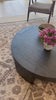 Made from thick, charcoal-finished oak, a rounded coffee table features four legs that pull through to the top, for an intriguing design detail.Overall Dimensions: 48.00"w x 48.00"d x 13.00"hWeight : 94.80 lbsMaterials : Oak Veneer Amethyst Home provides interior design, new home construction design consulting, vintage area rugs, and lighting in the Winter Garden metro area.