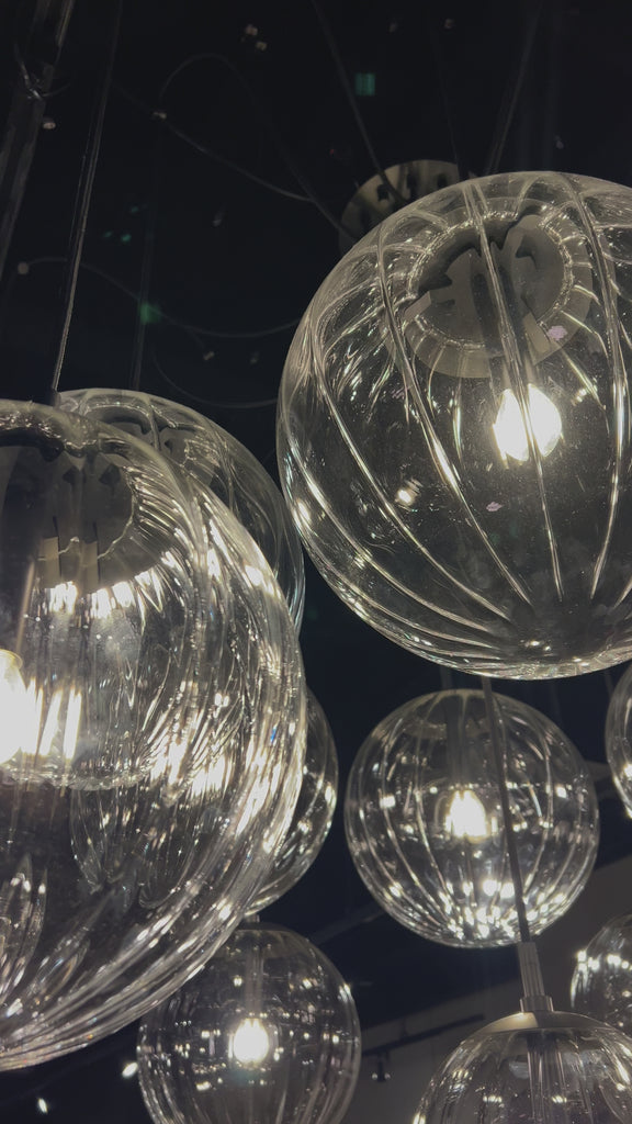 Clear glass spheres float at varying lengths for a statement-making piece. Each globe is individually blown, shaped and sculpted by hand through a one-hour process. The finish on the brass frame is achieved through a specialized process that turns the brass into an almost black hue before the rod is polished smooth. Brass and glass are 98% recyclable. Amethyst Home provides interior design, new home construction design consulting, vintage area rugs, and lighting in the Monterey metro area.