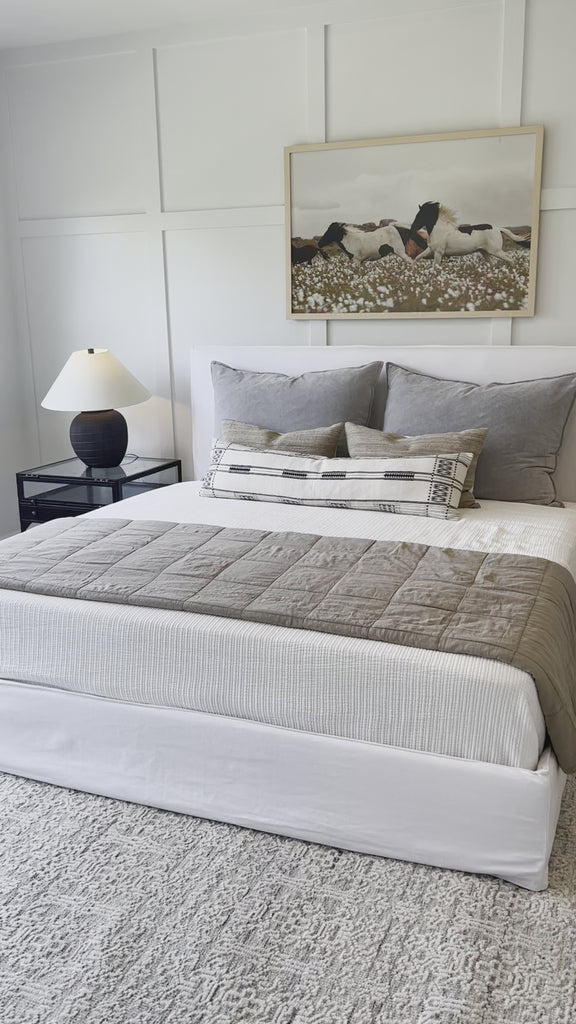 Cisco Brothers April Bed is designed and constructed in Los Angeles. The pinched edges and clean lines bring a modern, minimalist feel to any bedroom. Photographed in White Denim and Bengal Pin Striped Indigo. Amethyst Home provides interior design, new home construction design consulting, vintage area rugs, and lighting in the Newport Beach metro area.